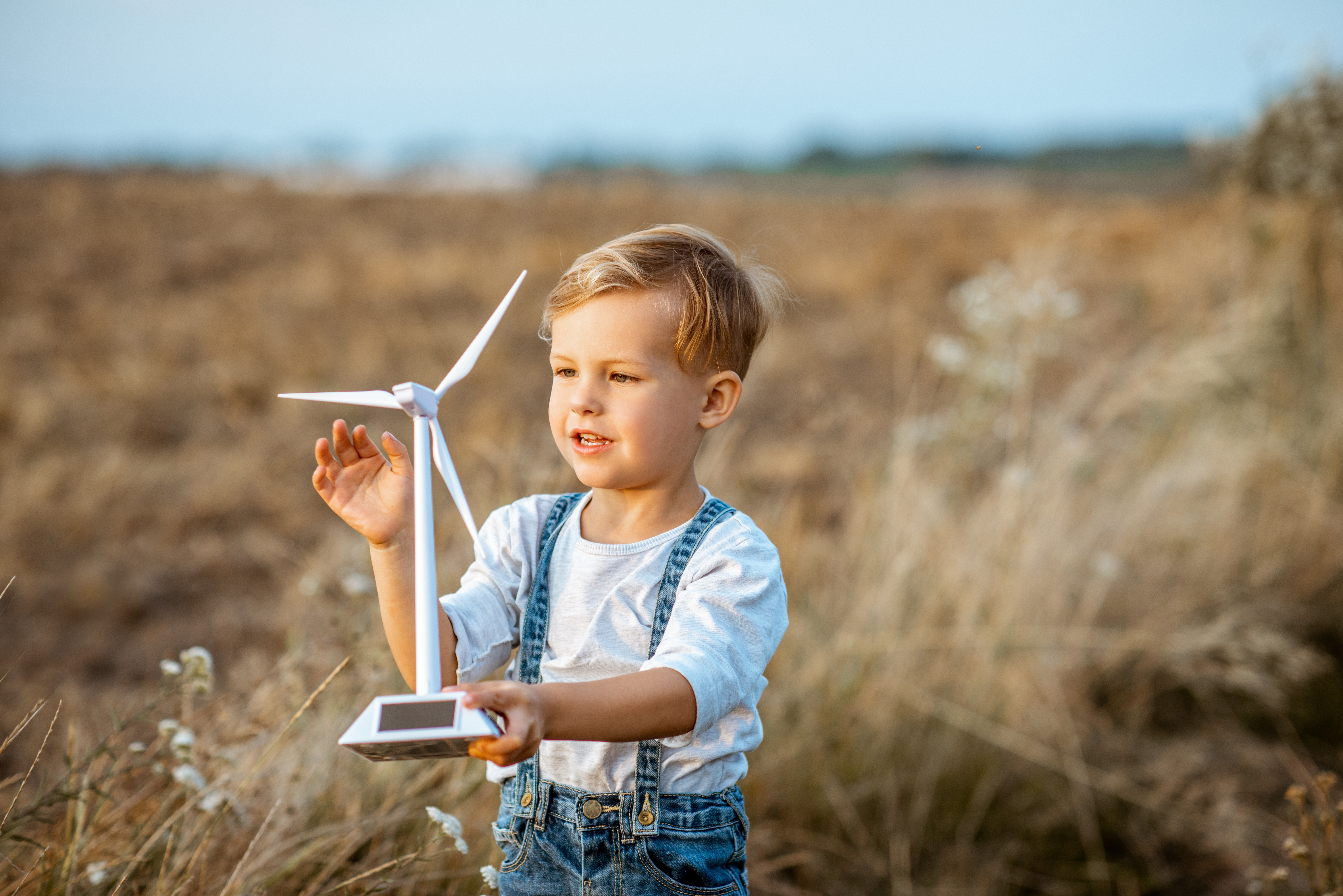 Child playing with toy wind turbine
